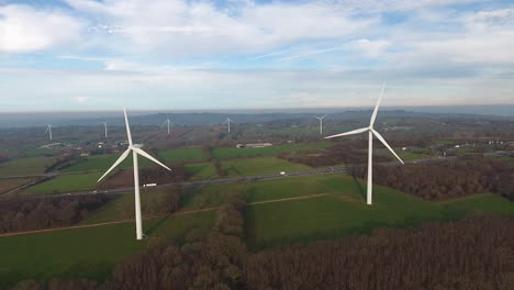 Windkraftanlagen-Entlang-Einer-Autobahn-Und-Feldern-In-Der-Normandie,-Frankreich.-Drohnen-Luftaufnahme